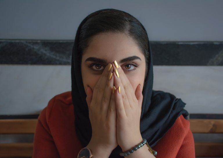 Indian girl covering her mouth expressing shock.